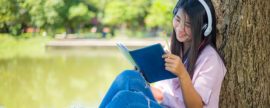 summer learning, reading against a tree